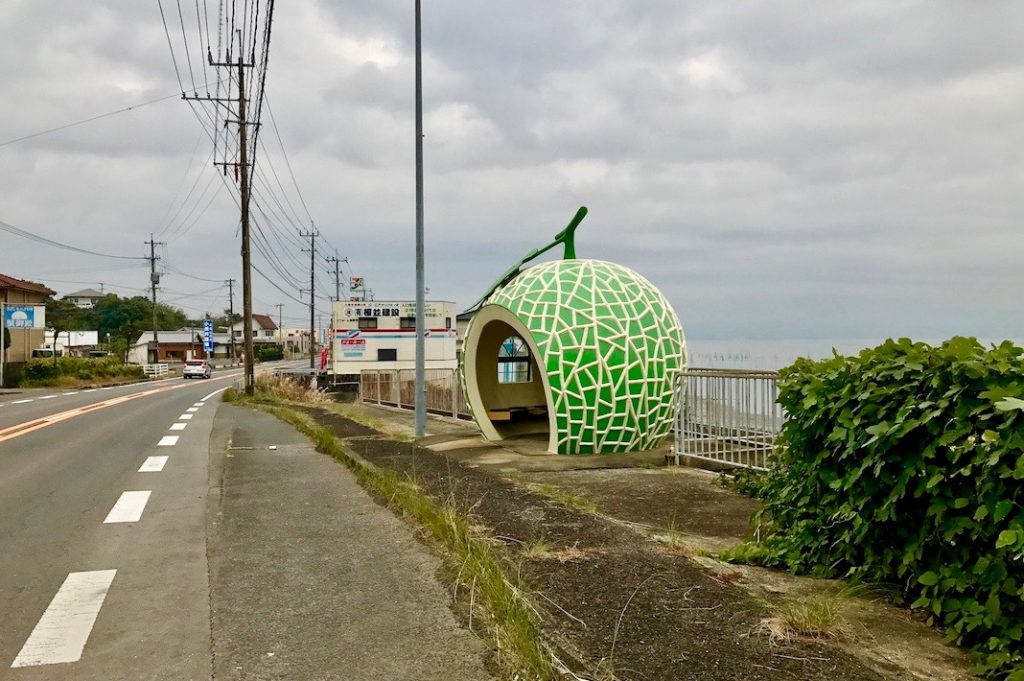 A melon-shaped bus stop along the coast. 