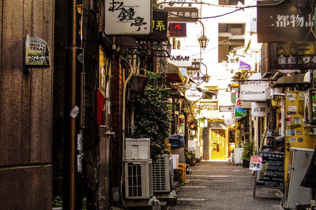 The collage-like storefronts of the Golden Gai are teeming with people on their own Shinjuku walks. 