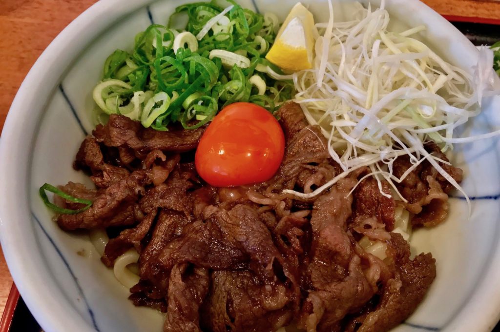 Sukiyaki-style beef with an egg yolk on udon