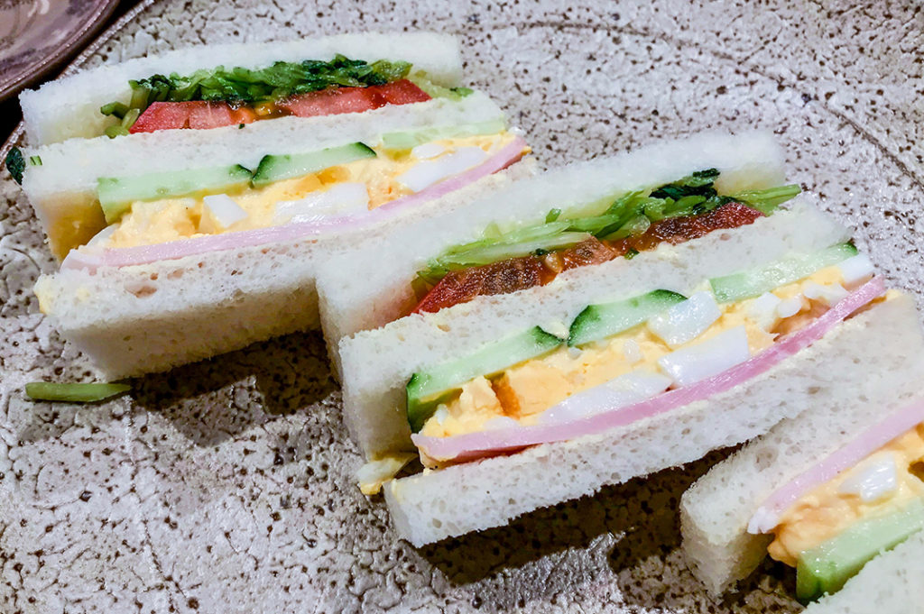 Egg, ham, tomato, and pickle sandwich