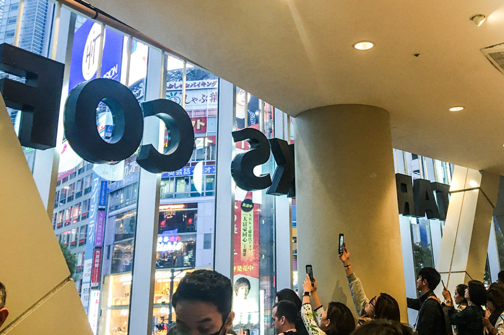 People taking photos of Shibuya Crossing from Starbucks