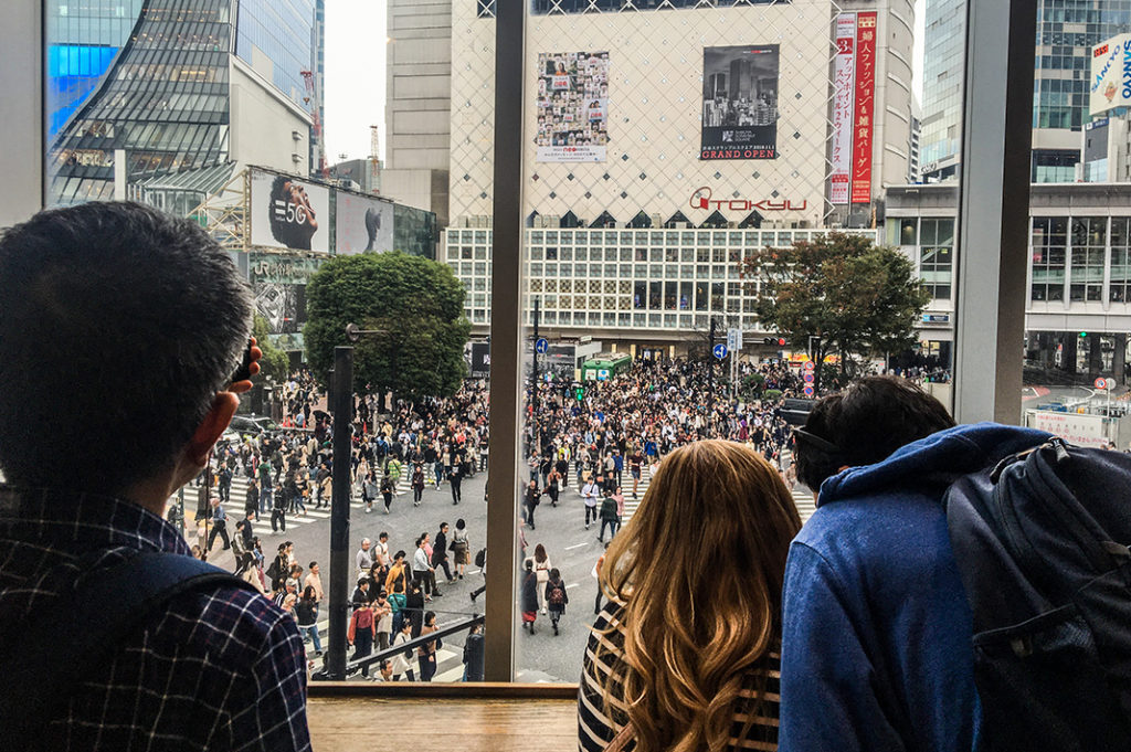 People taking photos of Shibuya Crossing from Starbucks