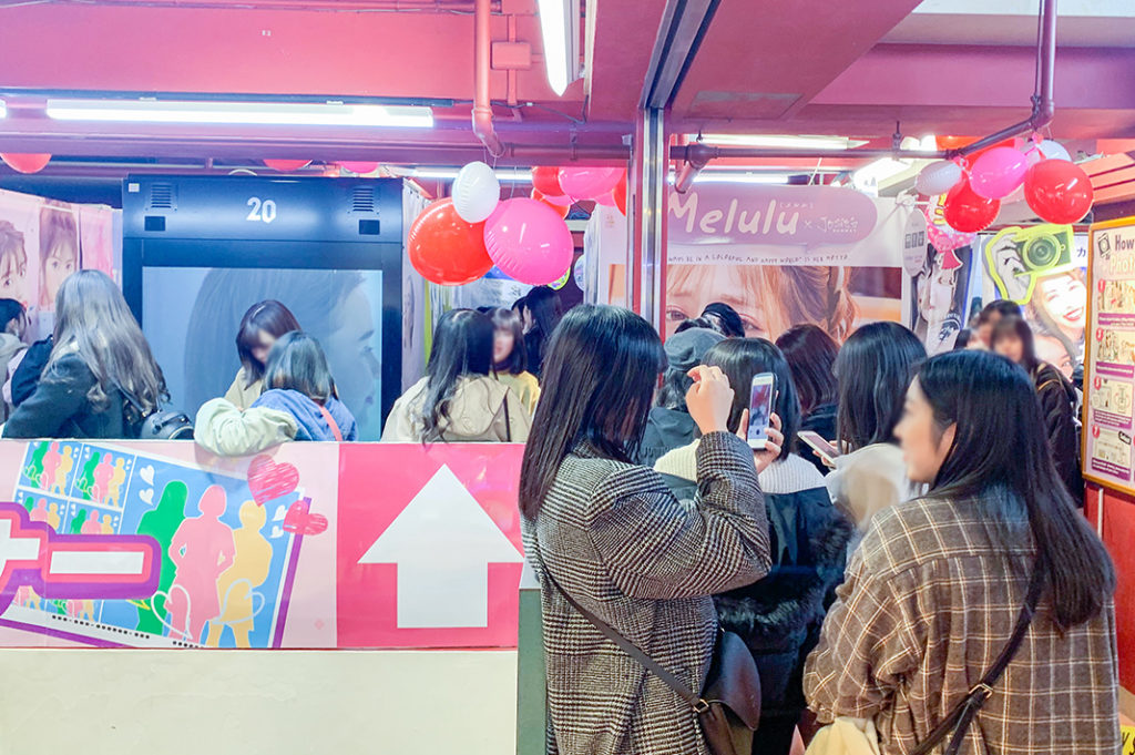 Tieners wachten op hun beurt bij de Purikura fotocabines in Shibuya