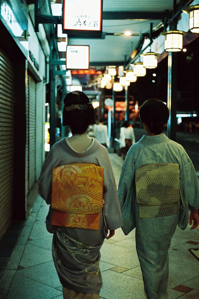 A 'unicorn moment' of Kyoto life: a graduated Geiko and her chaperone walk the neon-lit streets of Gion. Most people on the street were too engrossed in their phones to look up and notice.