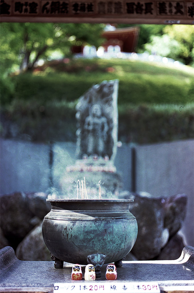 An incense bowl burns before a carved statue of Fudō-myoō at the lower levels of the temple.