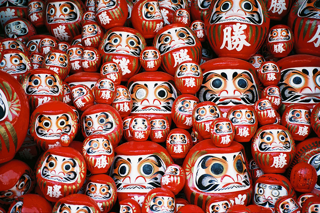 Darumadness! Hundreds of bright red Daruma dolls are stacked high at the lower levels of the temple.