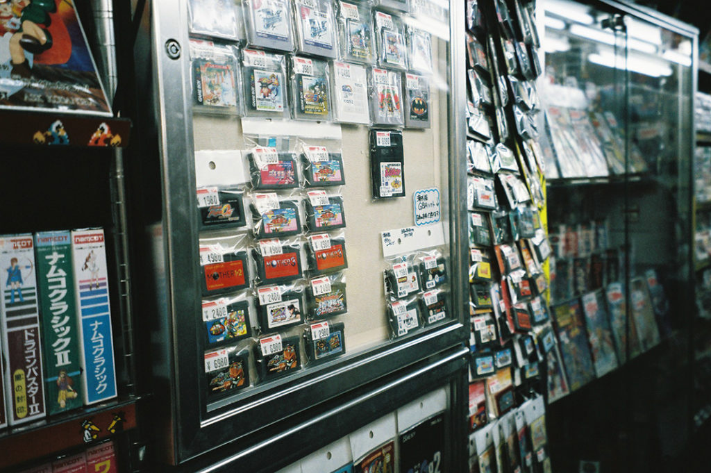 Game cartridges from the 1990s line the walls in many of the district's used gaming goods stores.