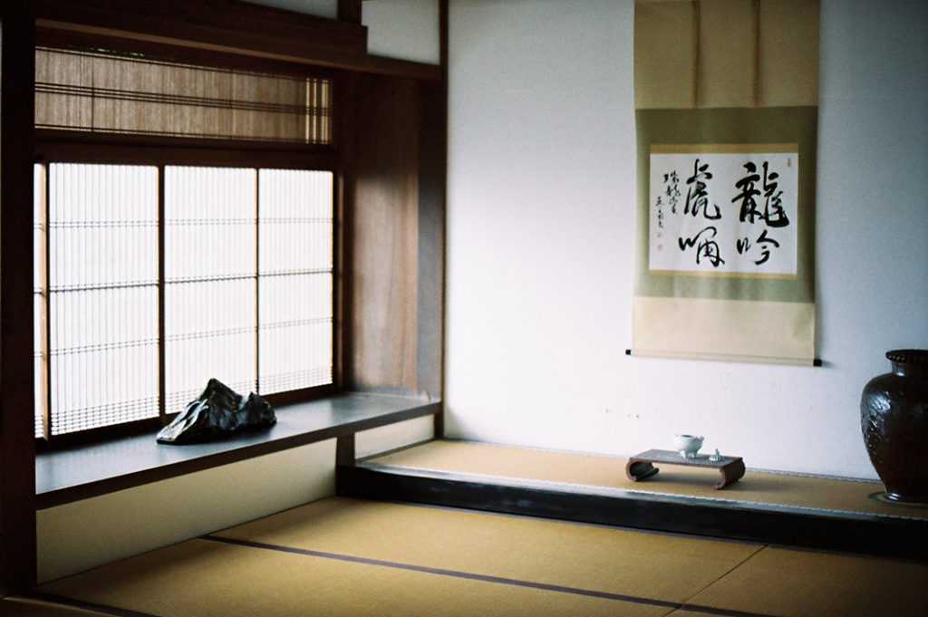 A space for quiet appreciation: a room within the temple featuring a calligraphy scroll and ornamental urn.