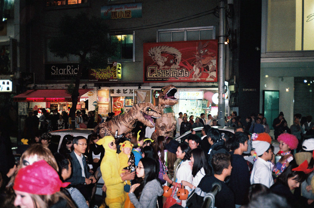 Halloween in Japan is truly an event unlike any other. [A large crowd in Halloween costumes fills a park in Osaka at night].