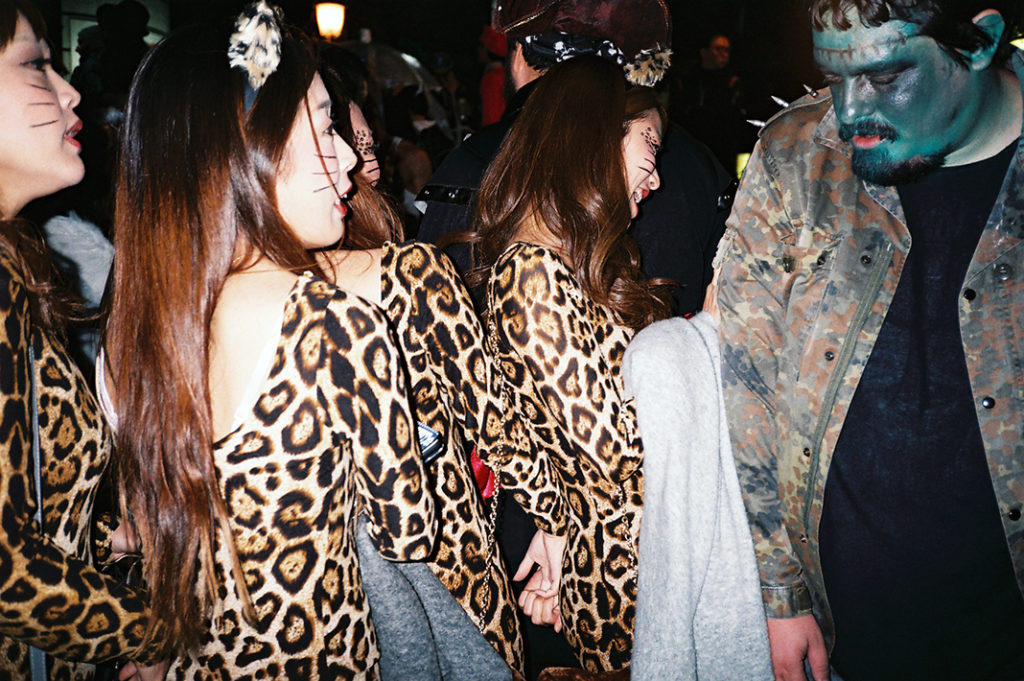 Four young women dressed as leopards walk past a foreign man dressed as Frankenstein's monster during a Japanese Halloween event in Osaka, Japan. 1 point!