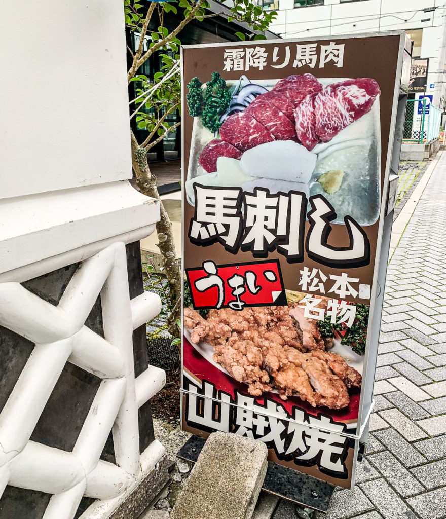 Sign advertising two popular Matsumoto foods: Basashi and Sanzoku yaki chicken which is unique to Matsumoto