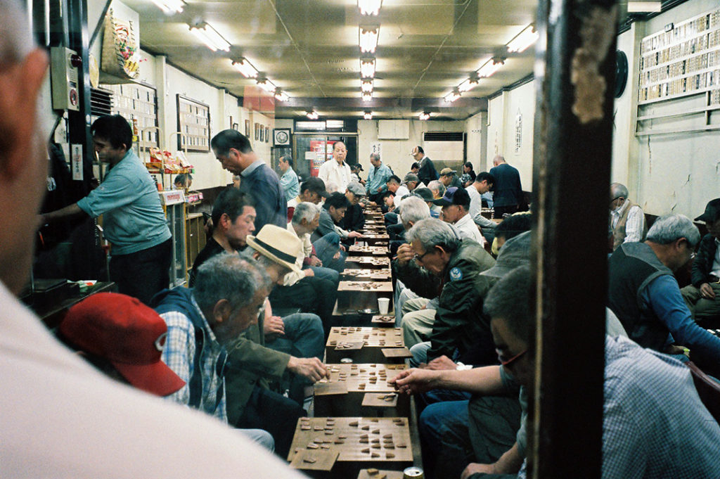 Elderly men gather to play Go and Shogi [traditional Japanese board games] at public premises. Locations such as this don't prohibit entry to anyone, but it's implicitly understood that both women and foreigners have no reason to be here.

Tags: Airin neighbourhood in Osaka, Nishinari district.