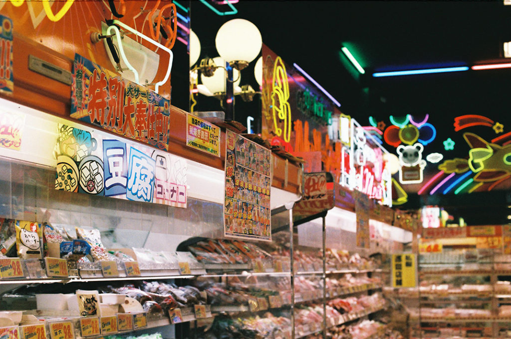 Cheerful neon lights serve to distract from the darker corners and storage areas of Super Tamade's premises.