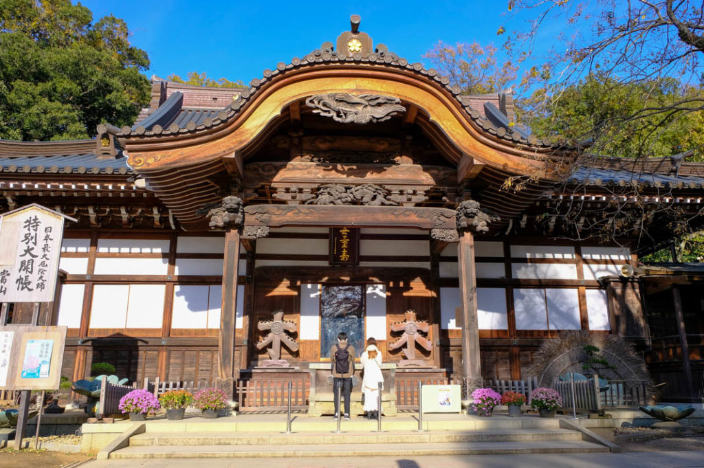 A couple praying at the Hon-do at Jindaiji Temple.