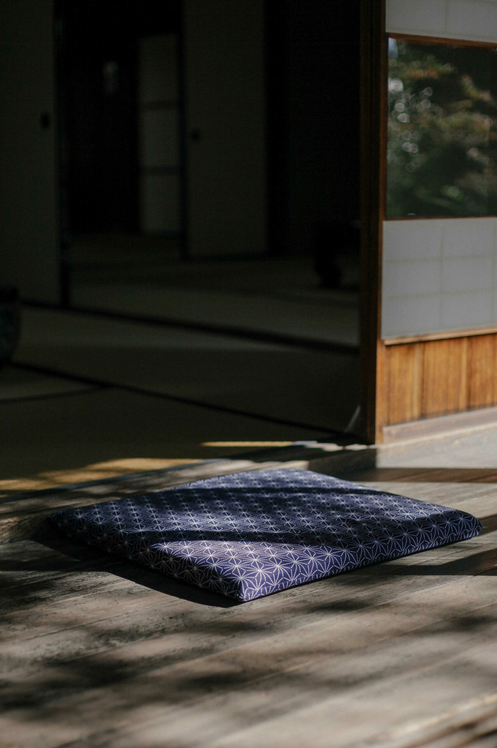 A simple cushion is positioned on the veranda at Sо̄seki Natsume's House.