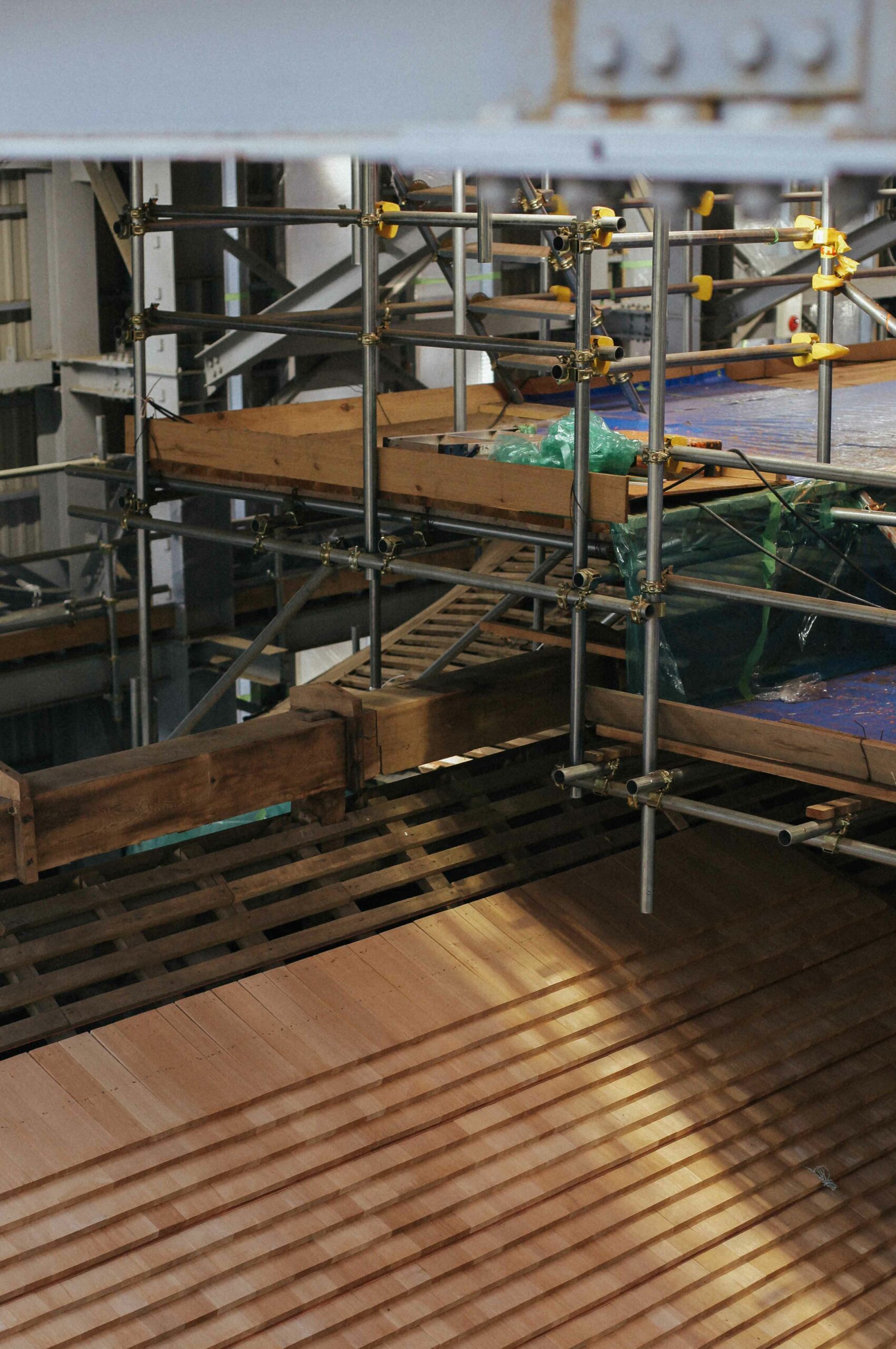 Scaffolding inside the covered building offers a unique opportunity to see newly laid cedar tiles.